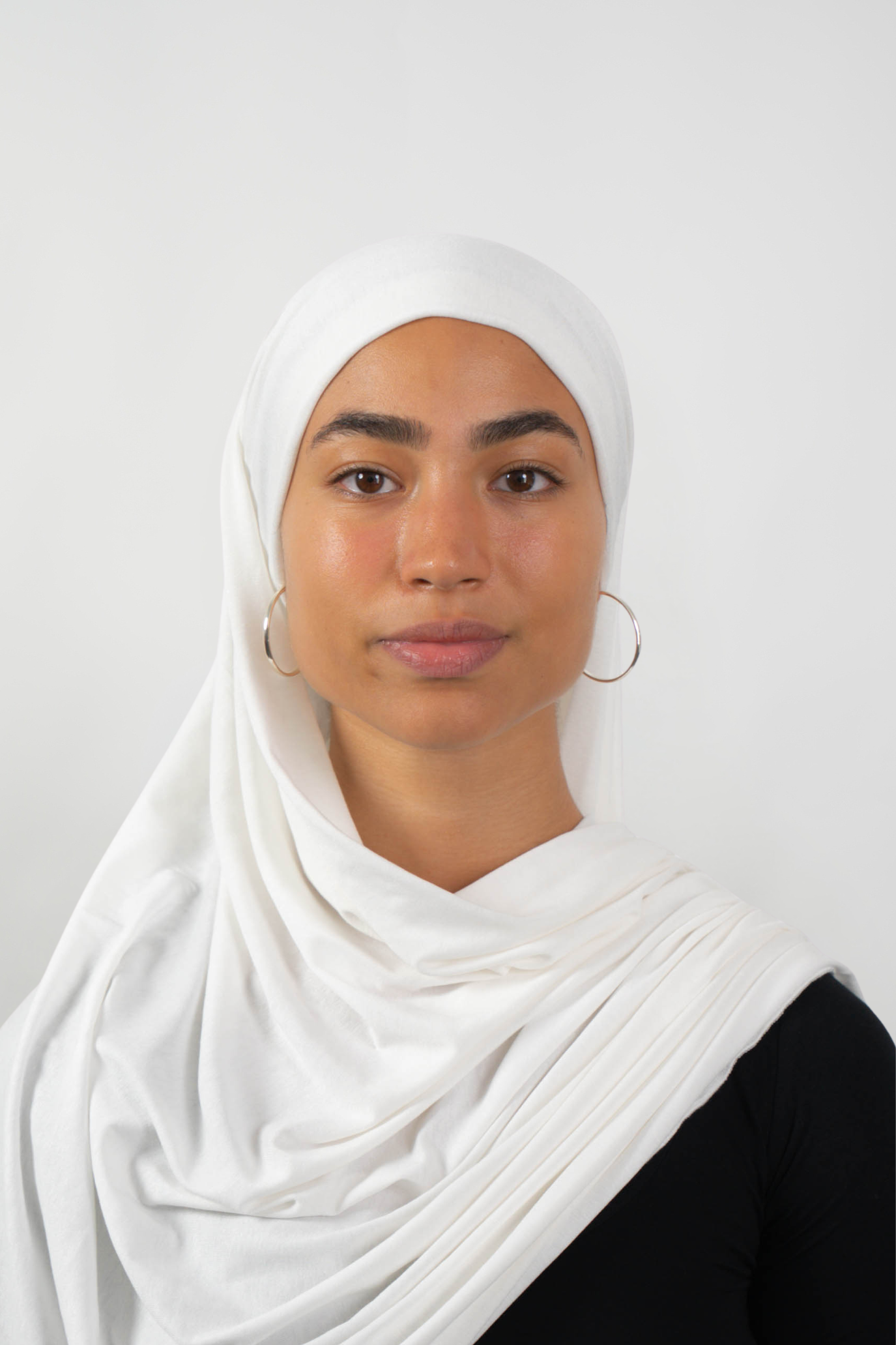 Weißer Hijab aus weichem Stoff, getragen von einer Frau – Produktbild im Online-Shop.