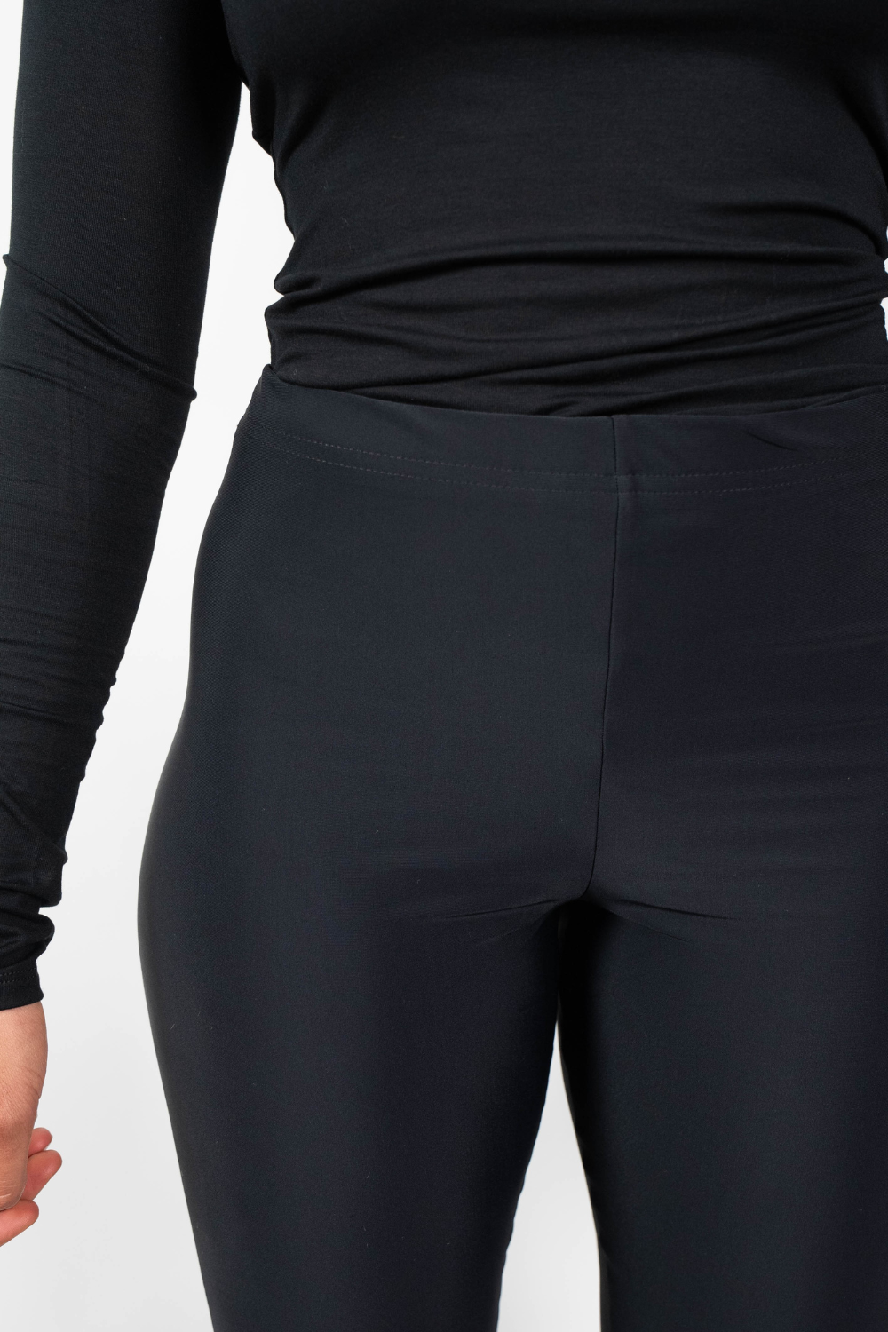 Nahaufnahme des oberen Bereichs der schwarzen, eng anliegenden Leggings, die den elastischen Bund und die Passform im Hüftbereich zeigt.