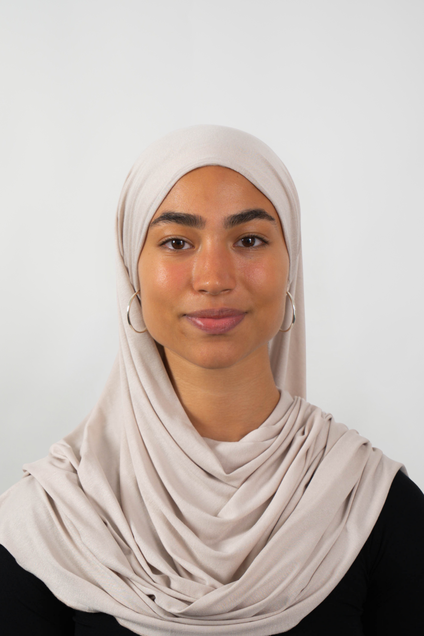 Cremefarbener Hijab aus weichem Stoff, getragen von einer Frau – Produktbild im Online-Shop.