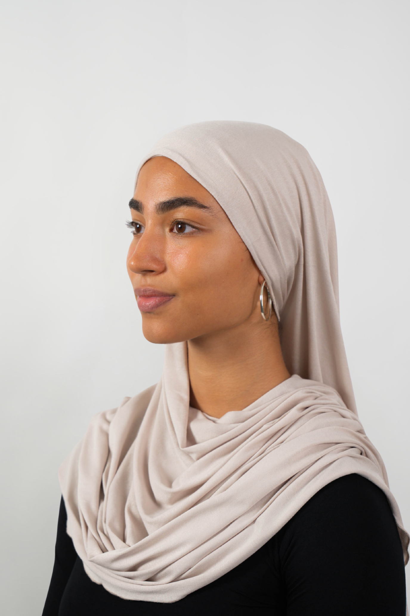 Cremefarbener Hijab aus weichem Stoff, seitliche Ansicht getragen von einer Frau – Produktbild im Online-Shop.