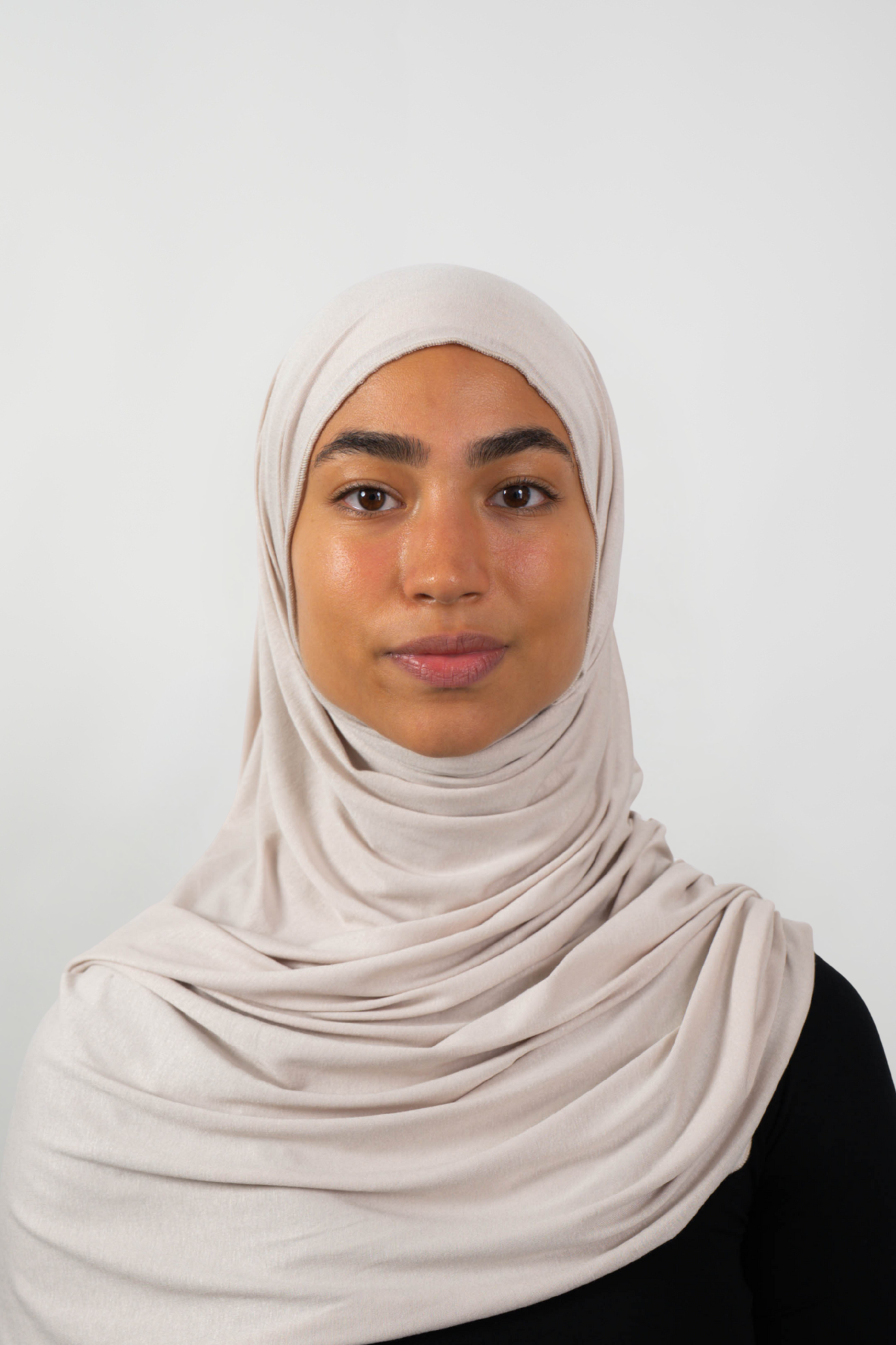 Cremefarbener Hijab aus weichem Stoff, getragen von einer Frau – Produktbild im Online-Shop.