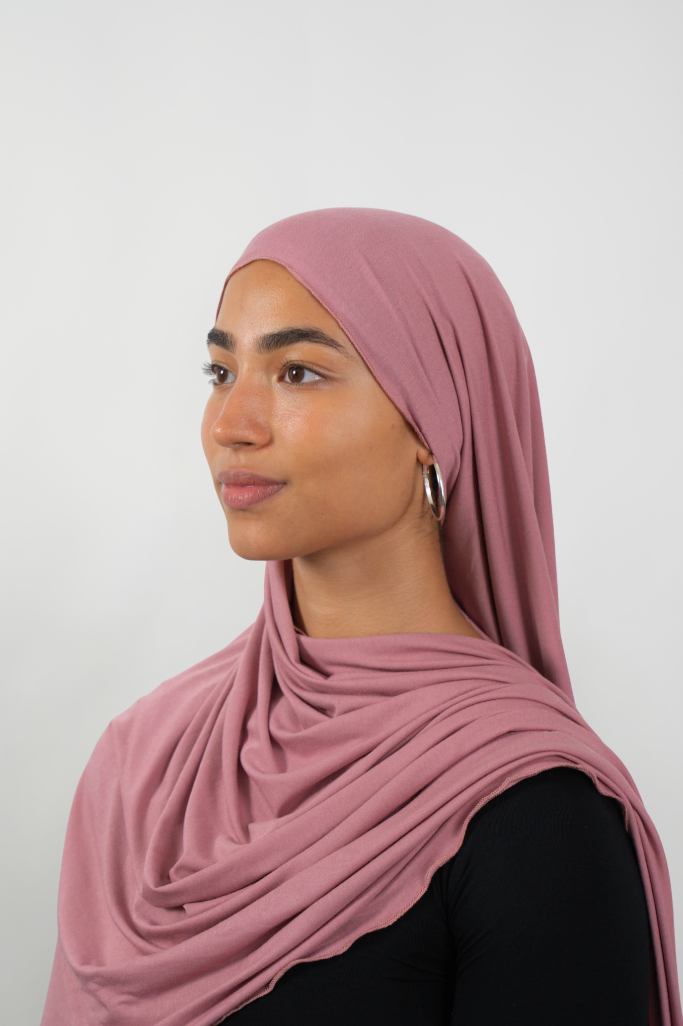 Roséfarbener Hijab aus weichem Stoff, seitliche Ansicht getragen von einer Frau – Produktbild im Online-Shop.
