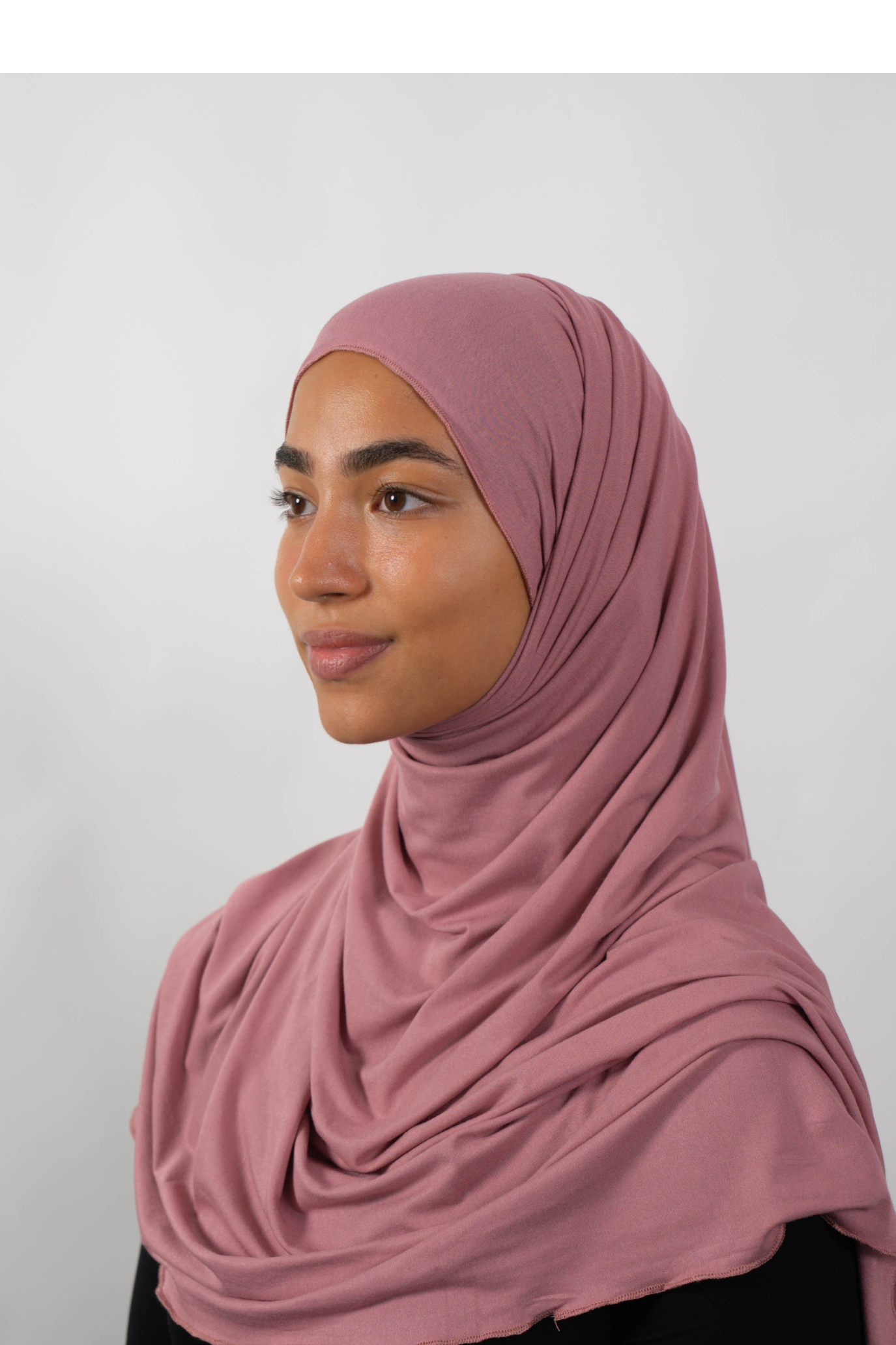 Roséfarbener Hijab aus weichem Stoff, seitliche Ansicht getragen von einer Frau – Produktbild im Online-Shop.