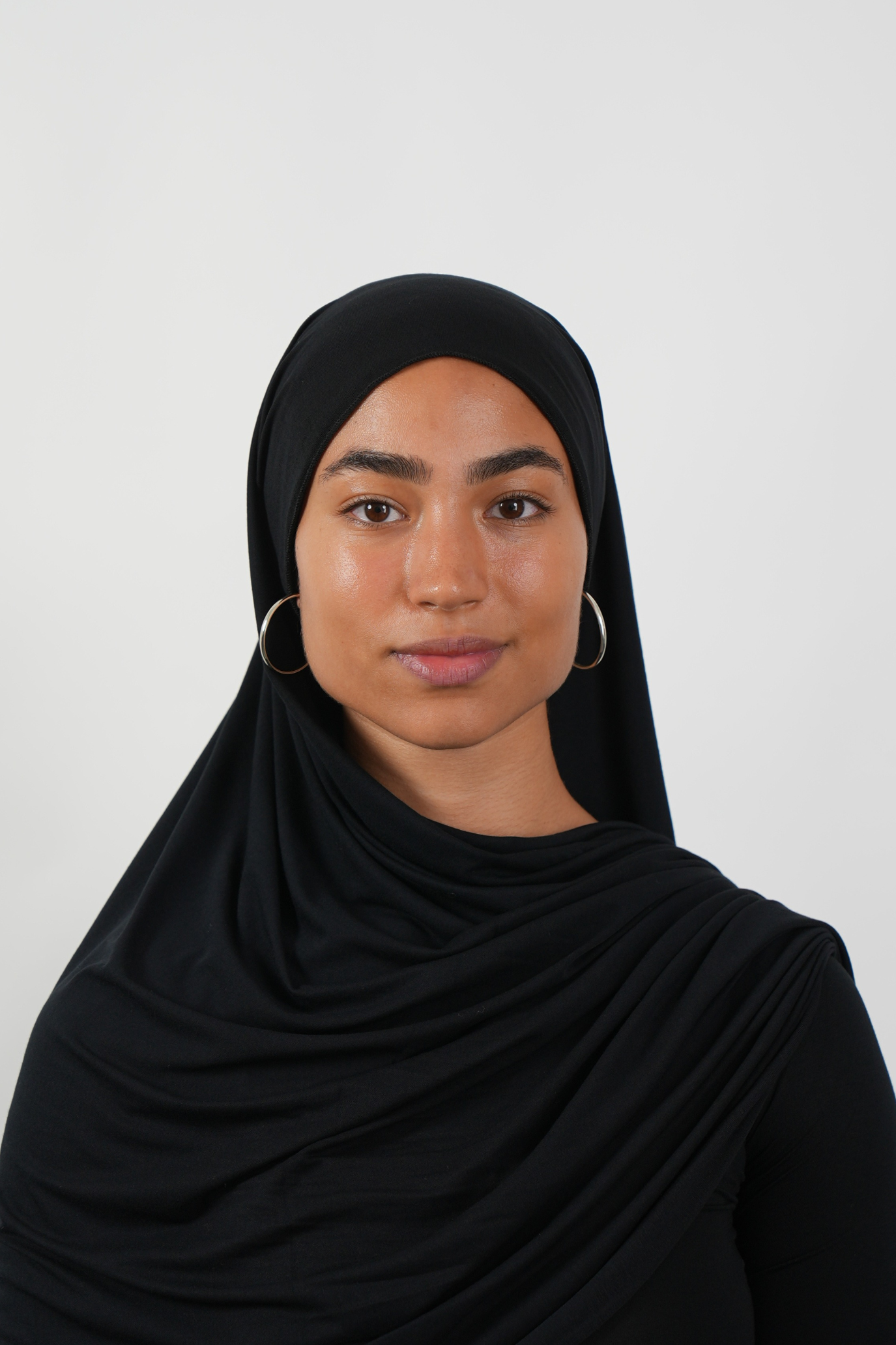 Schwarzer Hijab aus weichem Stoff, getragen von einer Frau – Produktbild im Online-Shop.