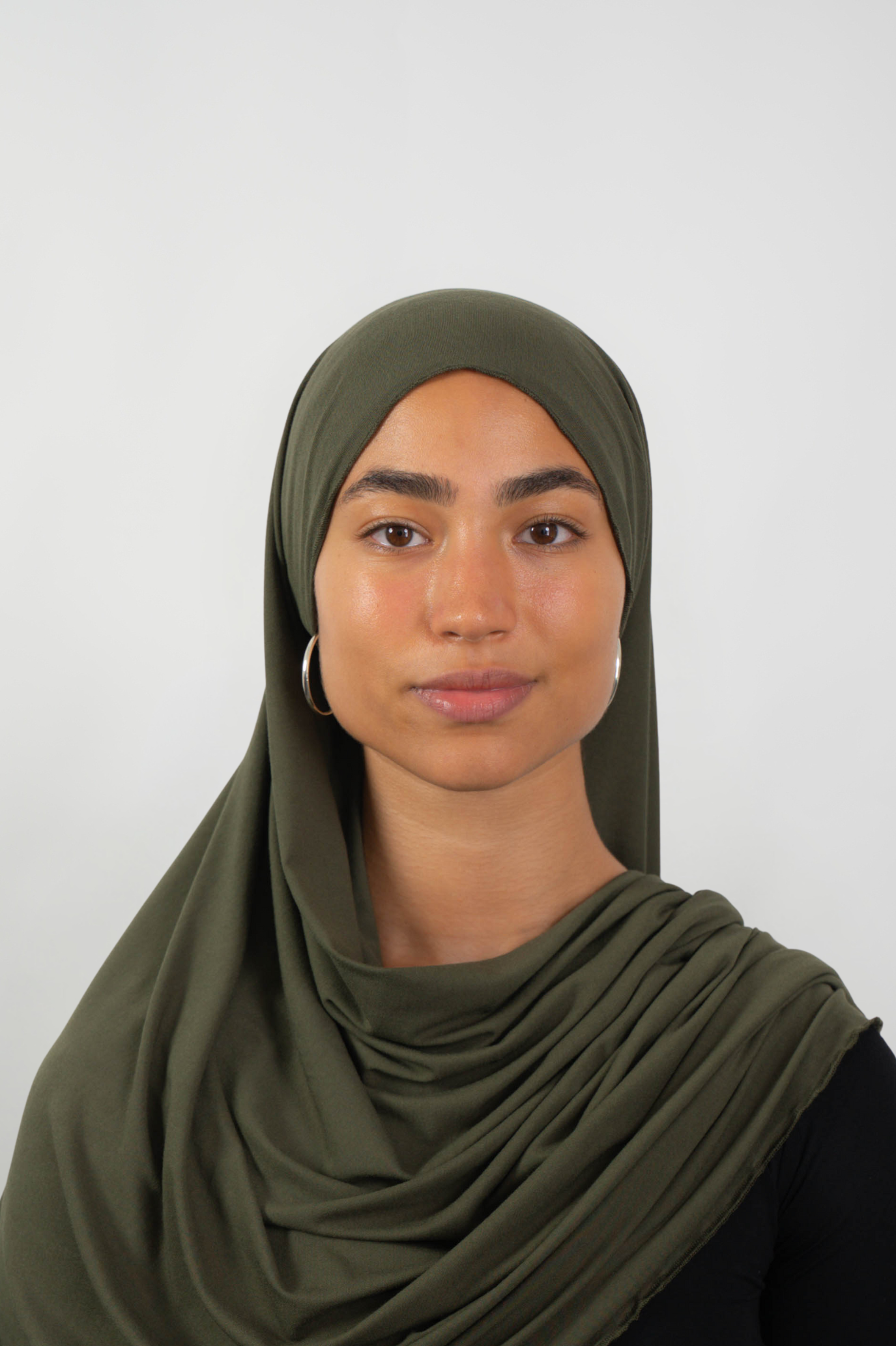 Olivfarbener Hijab aus weichem Stoff, getragen von einer Frau – Produktbild im Online-Shop.