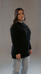 Woman wearing black Damen Hoodie Tawakkul, showcasing long cut and comfortable fit, expressing spiritual style.