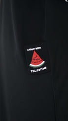 Schwarze Abaya mit "Living with Palestine"-Patch und Wassermelonenmotiv für kulturellen Ausdruck.