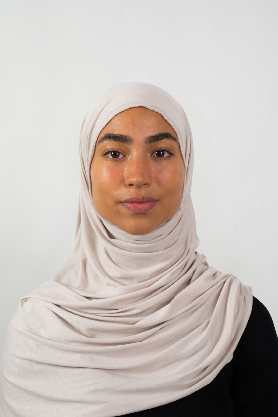 Cremefarbener Hijab aus weichem Stoff, getragen von einer Frau – Produktbild im Online-Shop.