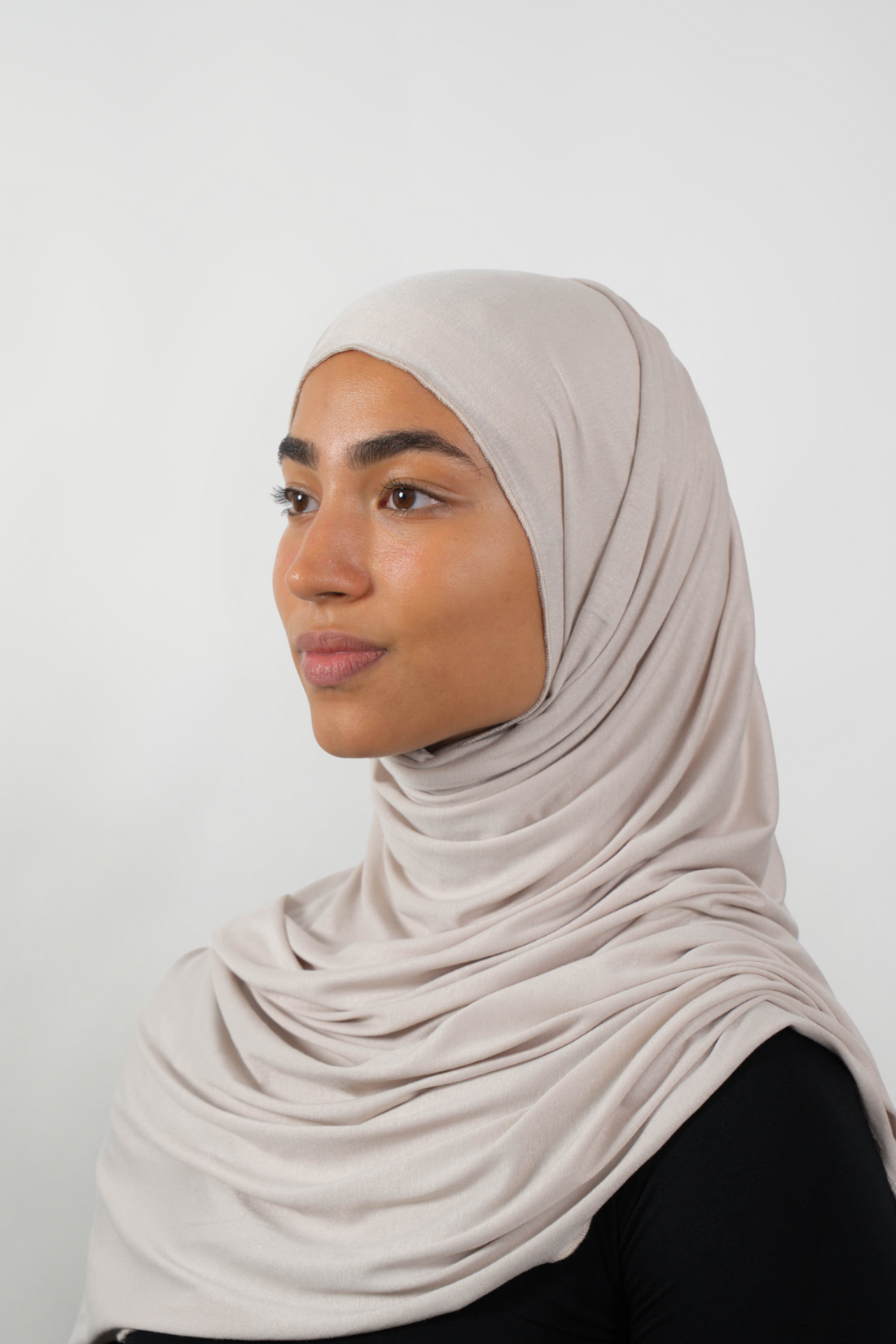 Cremefarbener Hijab aus weichem Stoff, seitliche Ansicht getragen von einer Frau – Produktbild im Online-Shop.