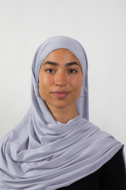 Grauer Hijab aus weichem Stoff, getragen von einer Frau – Produktbild im Online-Shop.