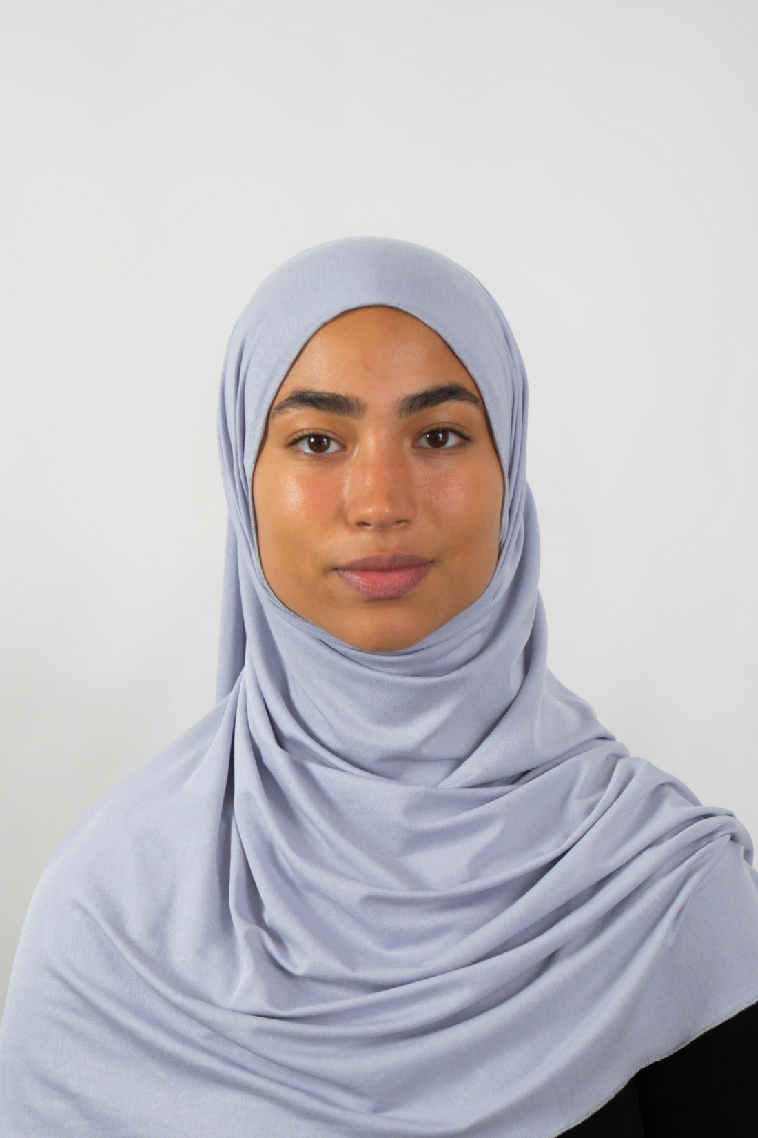 Grauer Hijab aus weichem Stoff, getragen von einer Frau – Produktbild im Online-Shop.