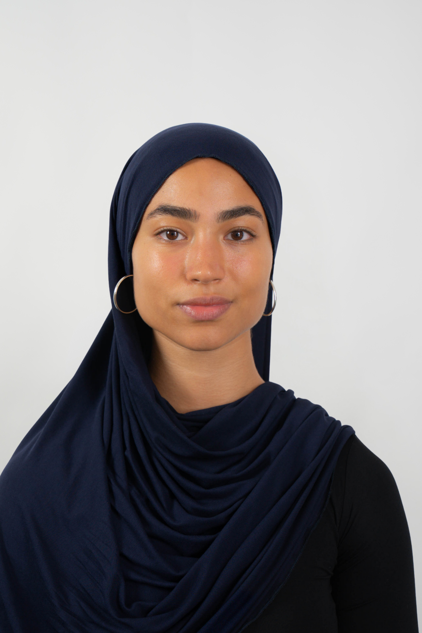 Dunkelblauer Hijab aus weichem Stoff, getragen von einer Frau – Produktbild im Online-Shop.