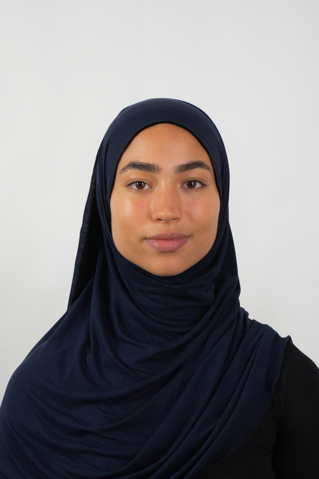 Dunkelblauer Hijab aus weichem Stoff, getragen von einer Frau – Produktbild im Online-Shop.