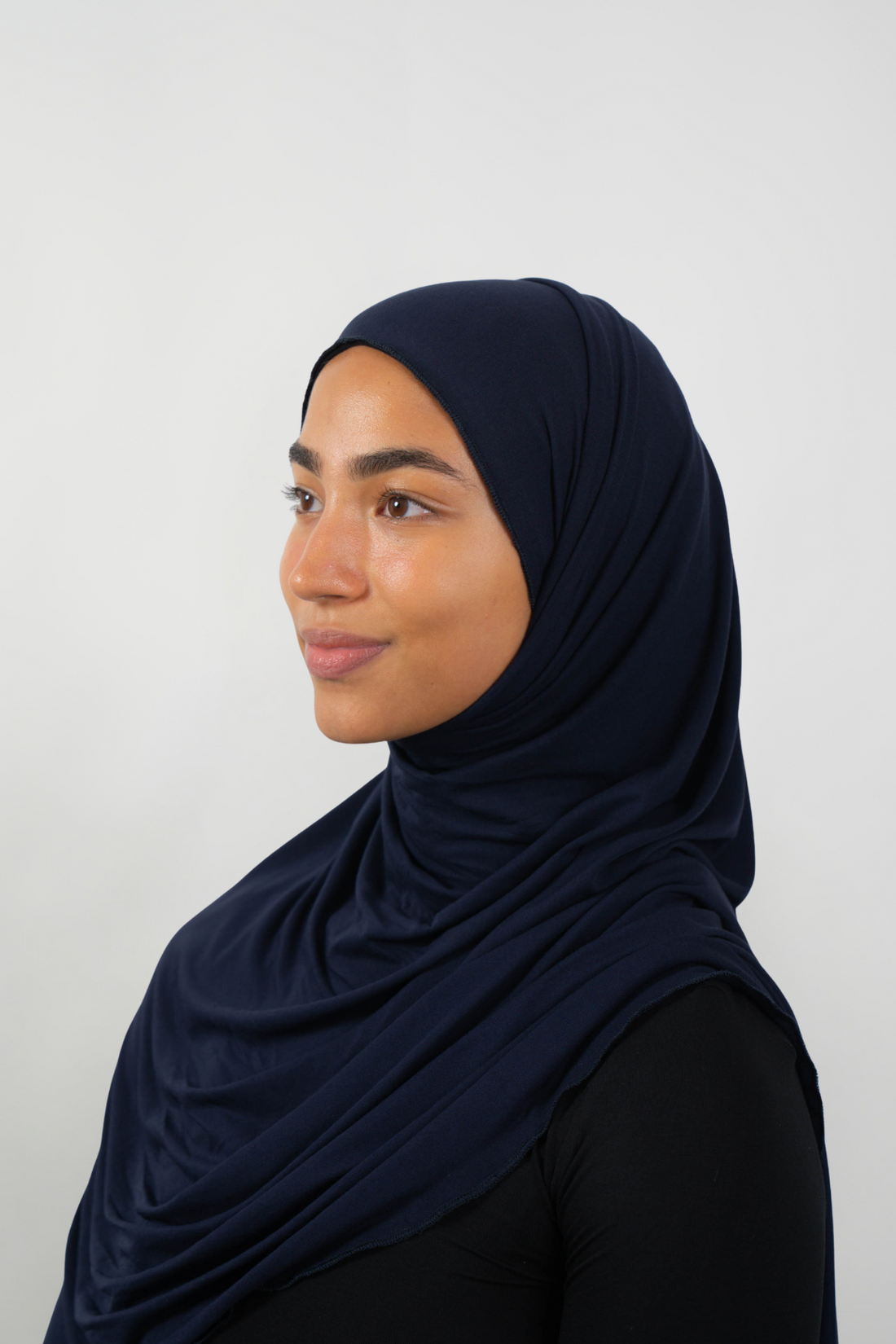 Dunkelblauer Hijab aus weichem Stoff, seitliche Ansicht getragen von einer Frau – Produktbild im Online-Shop.