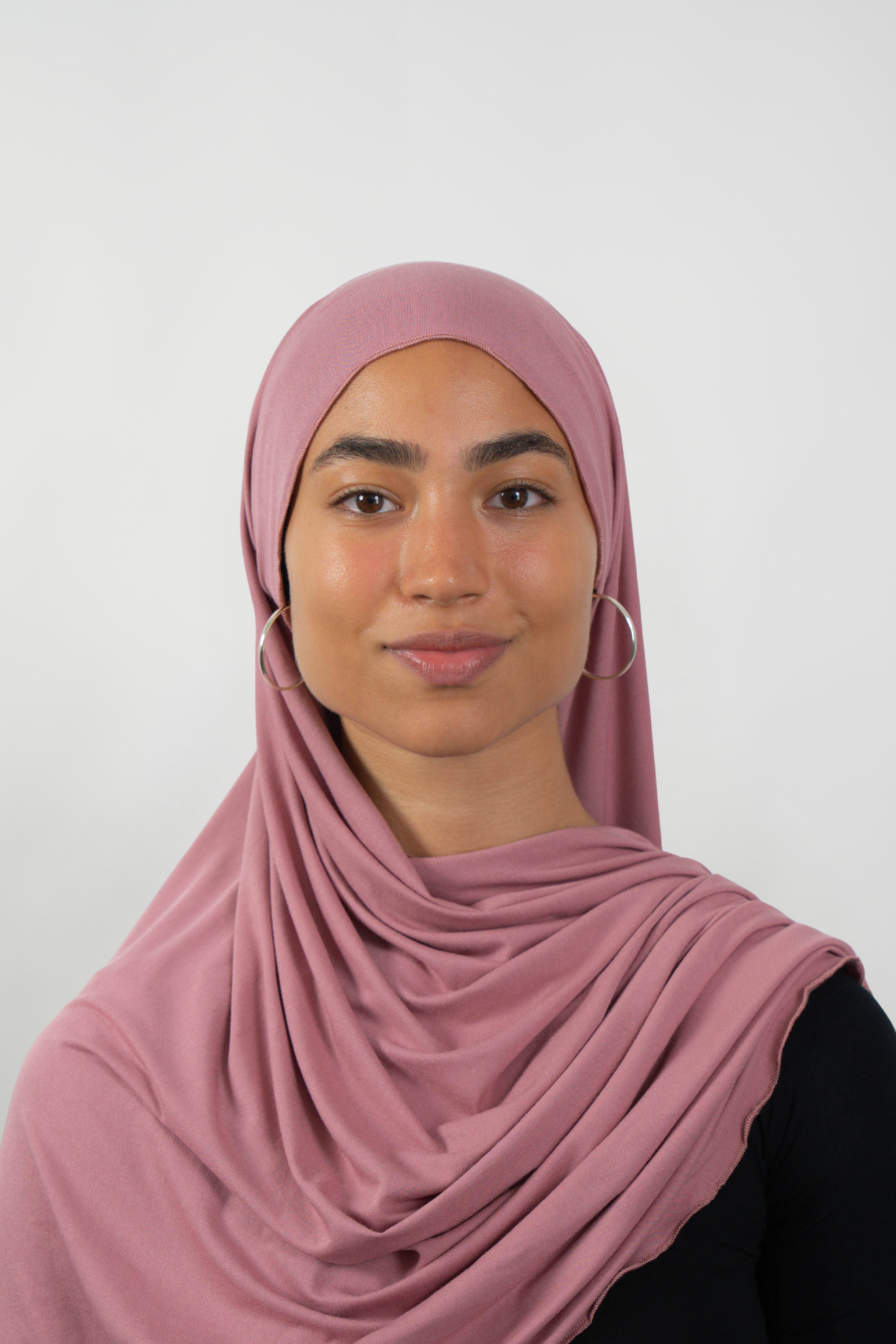 Roséfarbener Hijab aus weichem Stoff, getragen von einer Frau – Produktbild im Online-Shop.