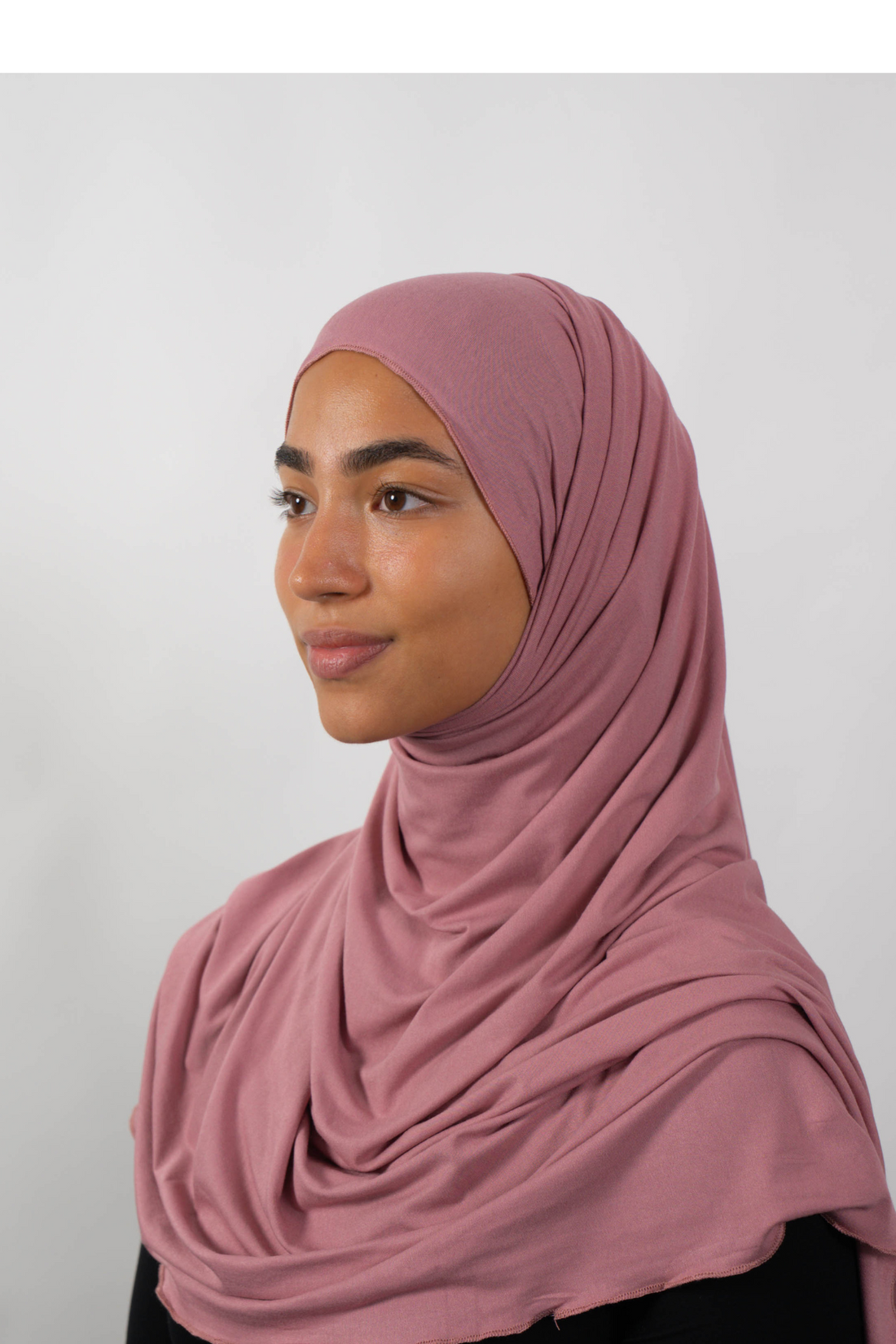 Roséfarbener Hijab aus weichem Stoff, seitliche Ansicht getragen von einer Frau – Produktbild im Online-Shop.