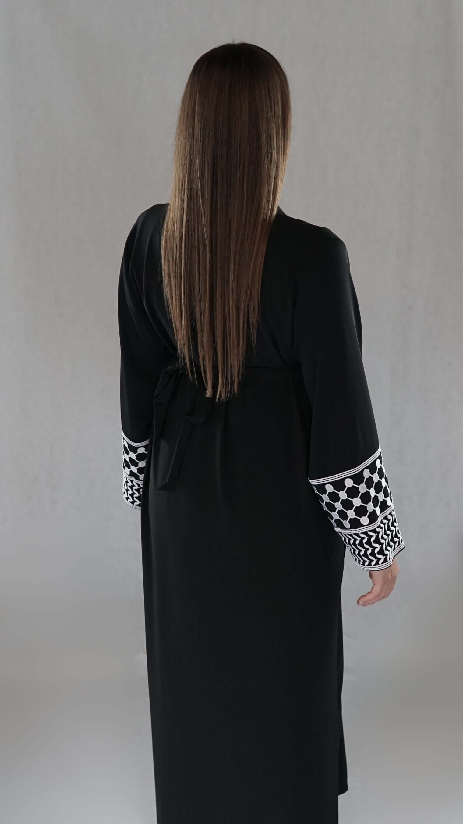 Schwarze Abaya mit traditionellem palästinensischem Muster an den Ärmeln, elegant und modern.