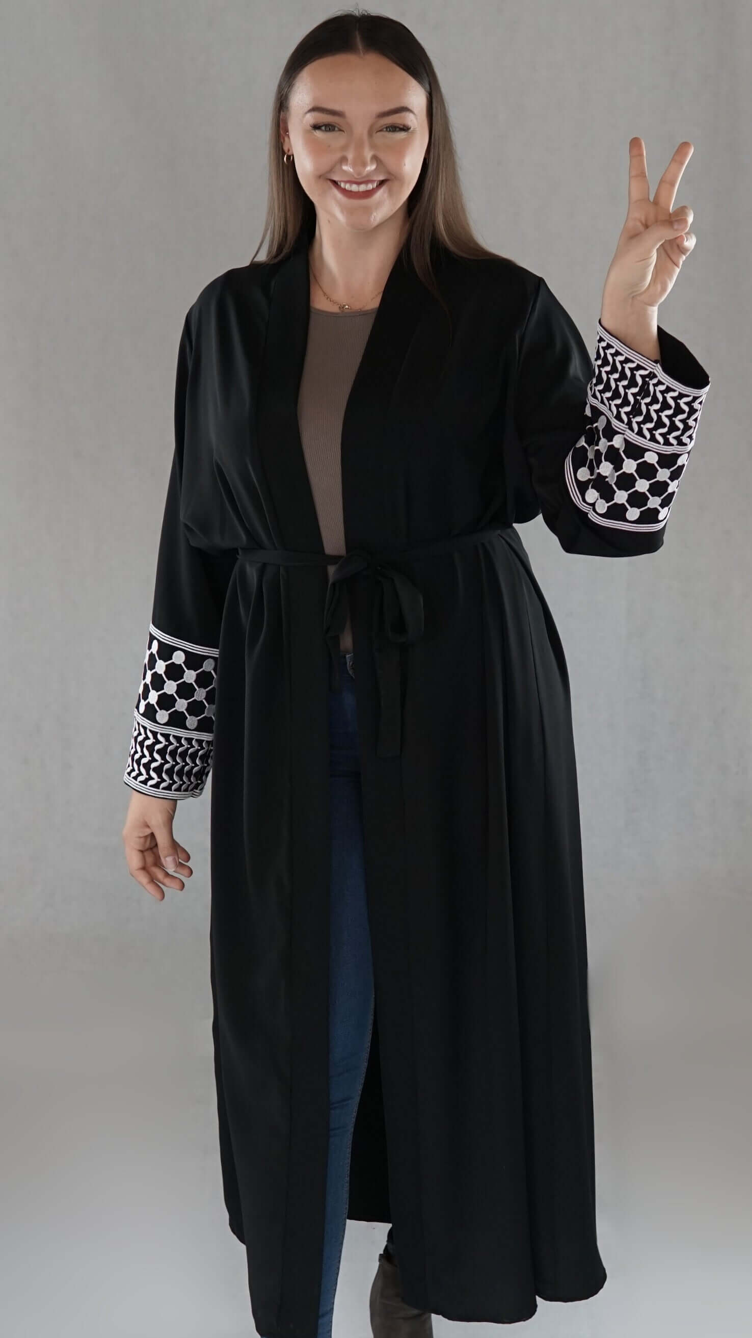 Schwarze Abaya mit palästinensischem Design, elegant mit symbolischem Olivenblattmuster und Fischernetzstruktur.