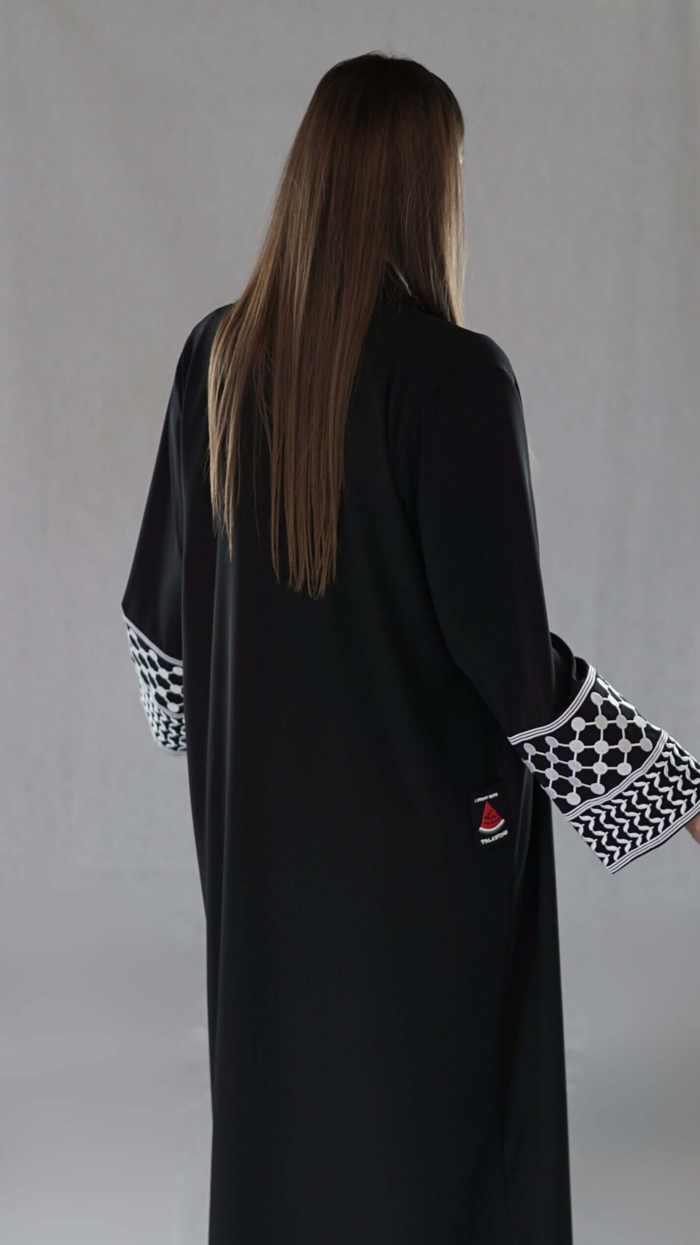 Schwarze Abaya mit traditionellem palästinensischem Design und detailreichen, gemusterten Ärmeln.