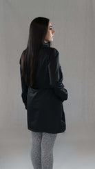 Woman wearing black Bade-Tunika with long sleeves, showcasing modern design and comfort for swimming.