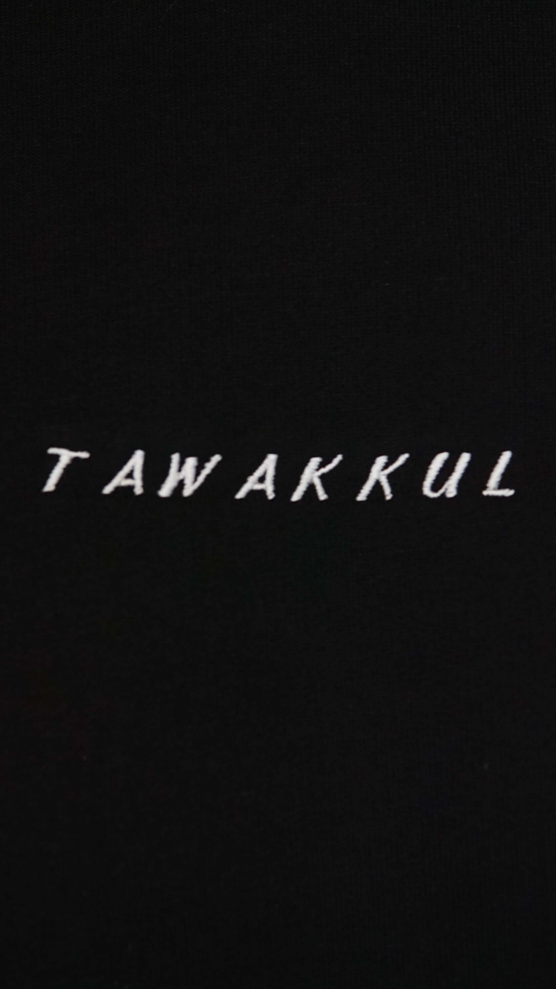 Black hoodie with white "Tawakkul" text on front, symbolizing faith and devotion.