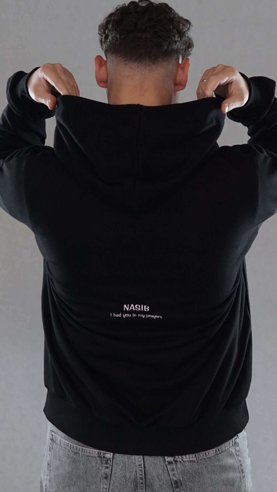 Oversized black hoodie for couples with "Nasib" graphic on the back, showcasing comfort and meaningful design.